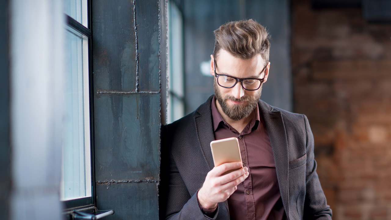 Hipster bearded man with glasses on phone